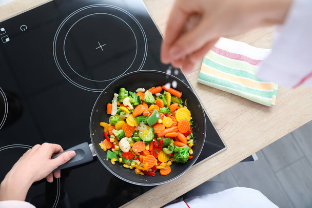 Naaraskokki suolaa paistettuja vihanneksia keittiössä - Valokuva, kuva