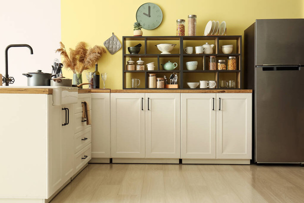 Modern konyha belseje fehér pulttal, polccal és hűtőszekrénnyel - Fotó, kép