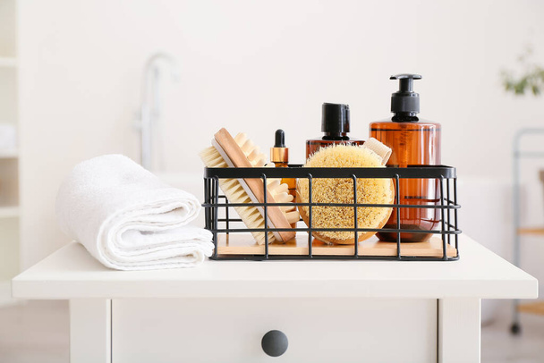 Basket with different bath supplies and towel on table - Photo, Image