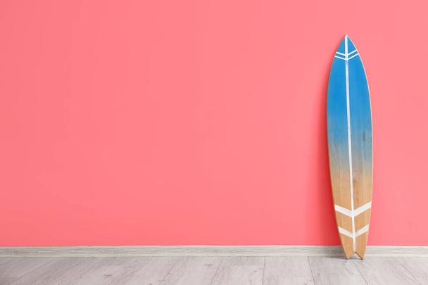 Tabla de surf de madera cerca de la pared rosa - Foto, Imagen