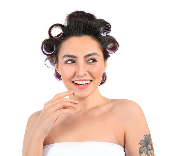 Happy young woman in hair curlers on white background - Zdjęcie, obraz