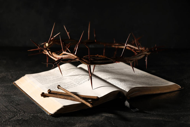 Crown of thorns with Holy Bible and nails on dark background - Photo, Image
