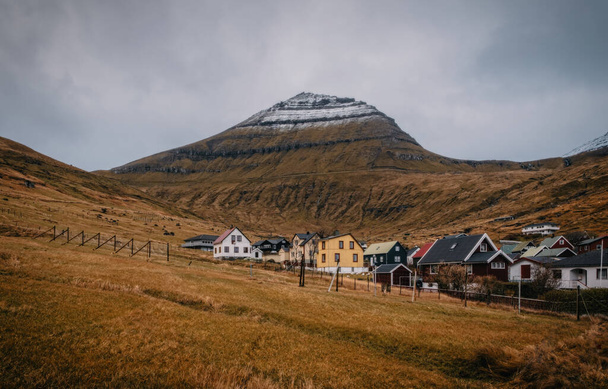 Colorate case del villaggio Funningur con un piccolo fiume e montagne eccezionali sullo sfondo. Isole Faroe, Danimarca. novembre 2021 - Foto, immagini