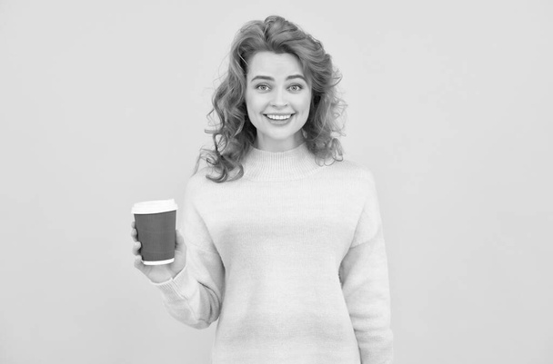 charmante roodharige vrouw gezicht portret drinken koffie uit papieren beker op gele achtergrond, goedemorgen - Foto, afbeelding