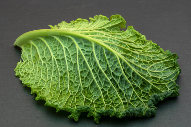 A folha de um repolho, close-up, mostrando as veias e estrutura da folha, em fundo cinza - close-up de alimentos - Foto, Imagem