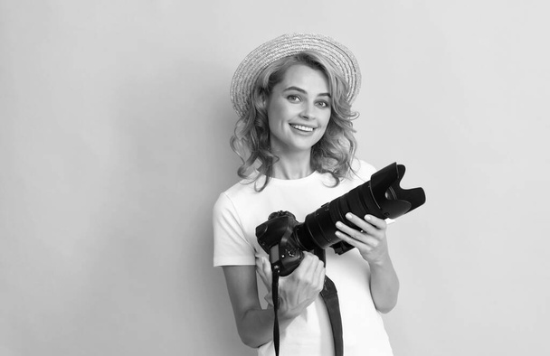 όμορφη γυναίκα φωτογράφος με κάμερα σε ψάθινο καπέλο κάνοντας φωτογραφία, φωτογραφία - Φωτογραφία, εικόνα