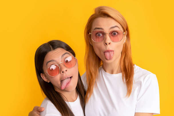 happy family portrait of single mother and daughter in glasses showing tongue, fun - Foto, imagen