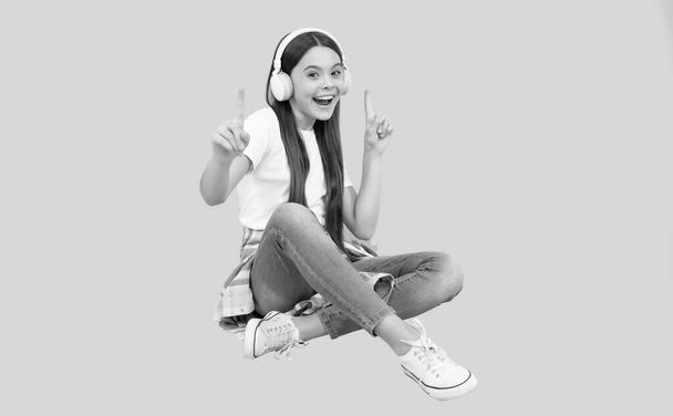 szczęśliwa dziewczynka słuchać muzyki w słuchawkach bezprzewodowych, akcesorium urządzenia - Zdjęcie, obraz