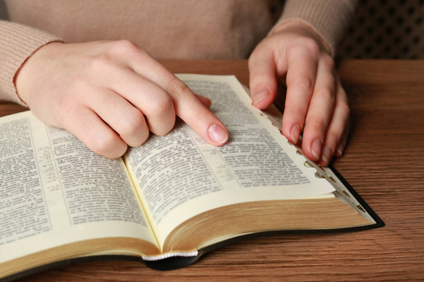 Woman reading Bible at wooden table, closeup - Photo, Image