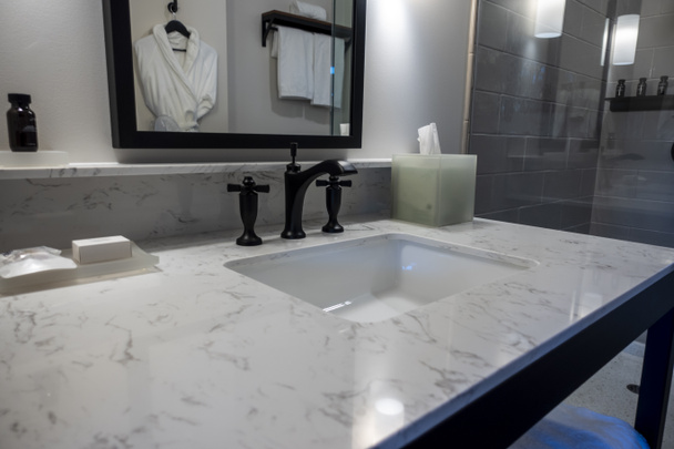 Concentration sélective sur un robinet d'évier de salle de bain noir moderne à l'intérieur d'un hôtel de luxe haut de gamme - Photo, image