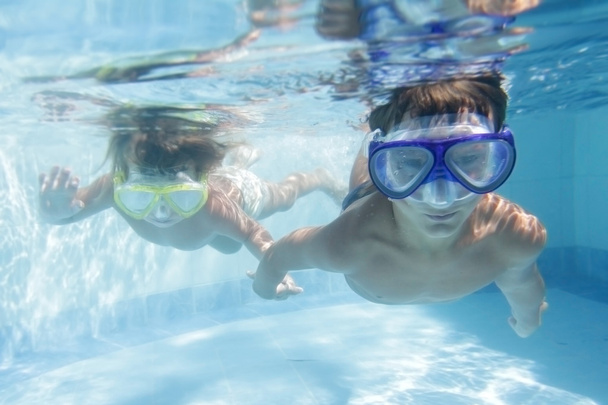 duas crianças mergulhando em máscaras subaquáticas na piscina
 - Foto, Imagem