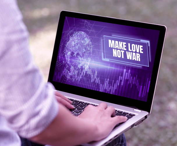 Tekst pokazujący inspirację Make Love Not War. Podejście biznesowe Hipisowski antywojenny slogan zachęcający do miłości i pokoju Kobieta wpisująca na laptopie Siedząca na zewnątrz Wstecz View Working From Home. - Zdjęcie, obraz