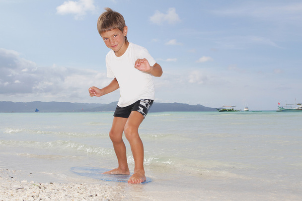 kleiner Junge mit Skimboard auf Meeresgrund - Foto, Bild