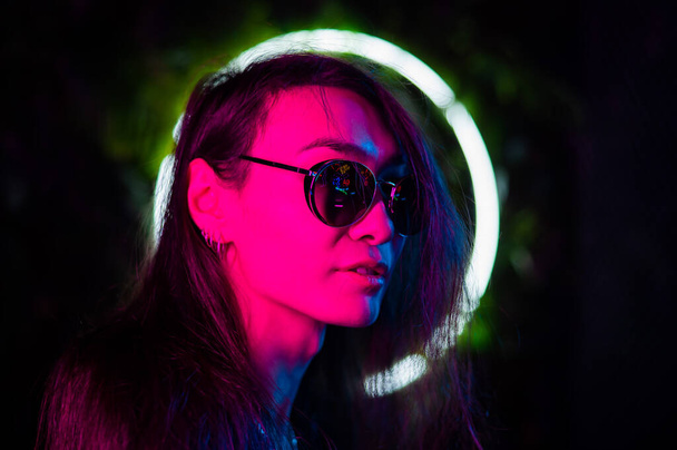 Portrait of asian man wearing sunglasses in neon light.  - Valokuva, kuva