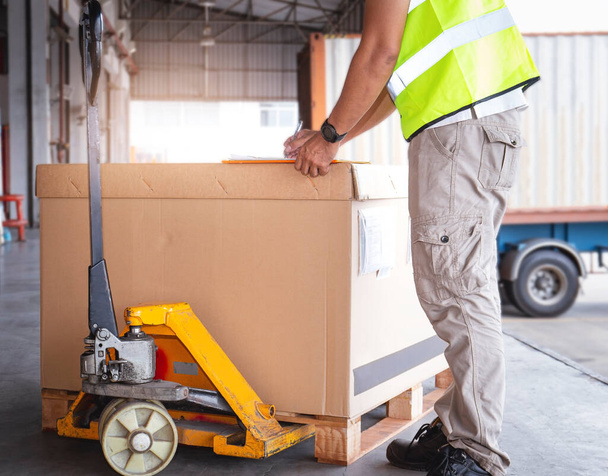 A Raktármunkás Csomagoló dobozokat ellenőriz, hogy küldjön-e ügyfeleknek. Hajózási Raktárkészlet menedzsment. Fuvarozási szolgáltatás. - Fotó, kép