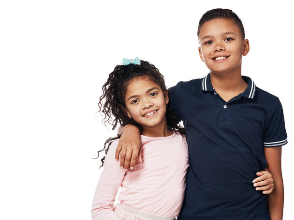 Brother and sister, aka, best friends. Studio portrait of a happy boy and girl embracing one another against a white background. - Foto, imagen
