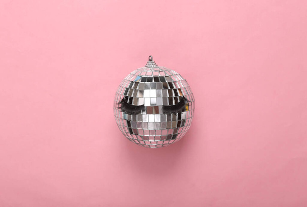 ελάχιστη διάταξη κόμμα. Καθρέπτης disco ball με ψεύτικες βλεφαρίδες σε ροζ φόντο. Άνω όψη - Φωτογραφία, εικόνα