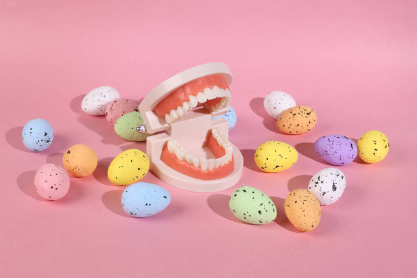 Mascella di plastica con uova di Pasqua colorate su sfondo rosa - Foto, immagini