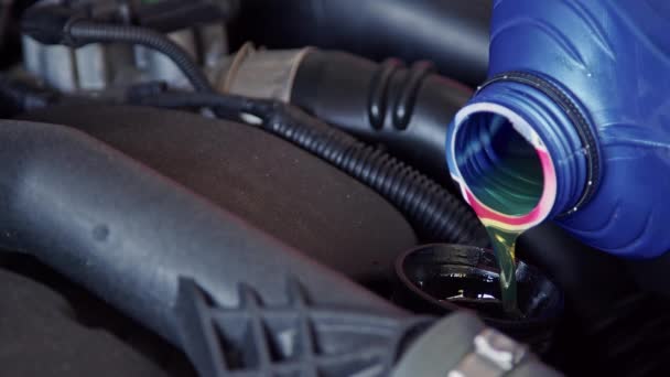 Versare nuovo olio motore in auto in riparazione negozio di filmati. - Filmati, video
