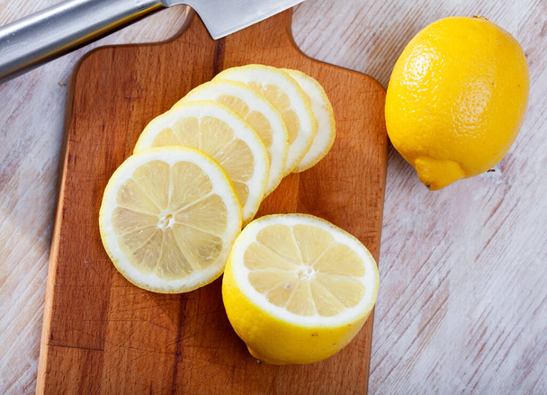 Sliced lemons on wooden table - Фото, зображення