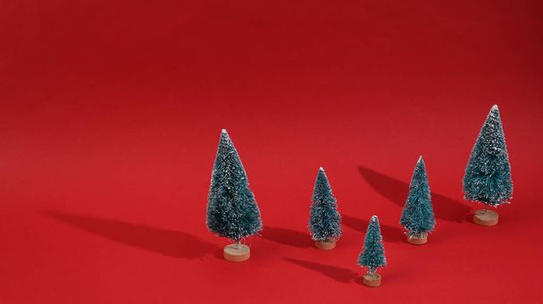 Christmas trees on a red background. Minimal Christmas layout - Foto, afbeelding