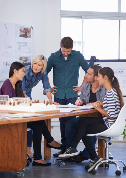 They listened intently to her solution. Cropped shot of a group of architects discussing a scale model. - Photo, Image