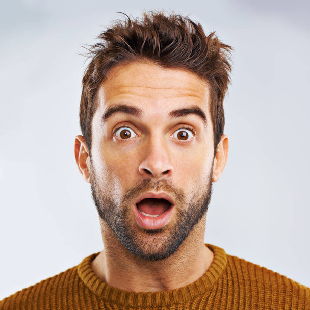 What just happened. Portrait of a shocked young man against a gray background. - 写真・画像