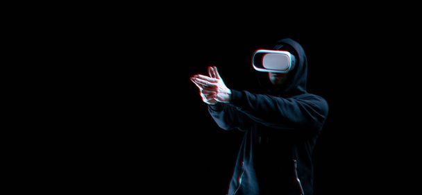 Vr bril virtual reality. Blured jongeman in digitale headset voor virtual reality-technologie op donkere achtergrond met glitch-effect. Geweldige technologie, online spel, entertainment - Foto, afbeelding