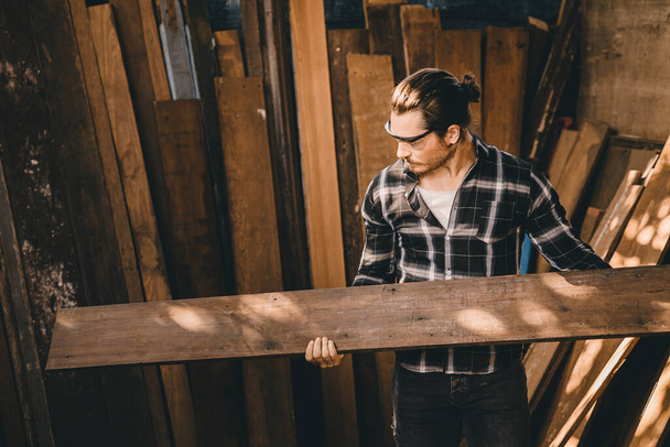 I falegnami uomo di alta esperienza operaio del legno che fa mobili. Maestro di legno maschio guardando pannello di legno. - Foto, immagini