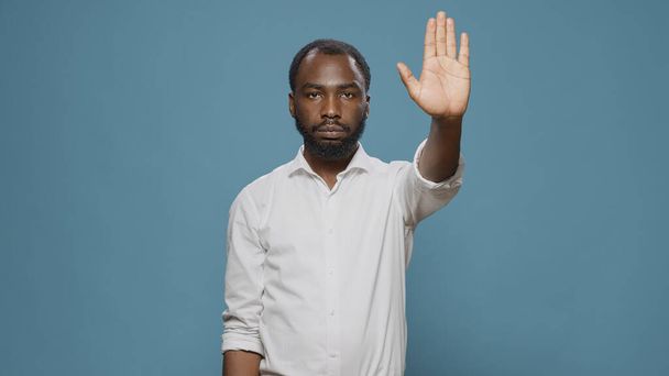 Modelo afro-americano levantando palma para anunciar sinal de stop - Foto, Imagem
