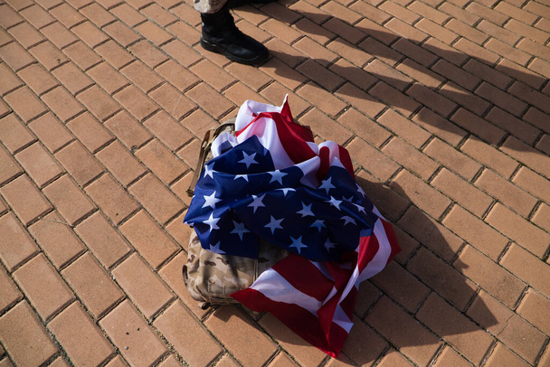 sac à dos militaire américain avec drapeau des États-Unis. Les bottes du soldat peuvent être vues d'un côté. Concept patriotisme, guerre, soldat. - Photo, image