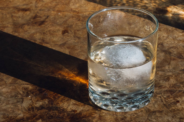 bicchiere d'acqua con ghiaccio sul tavolo di legno - Foto, immagini