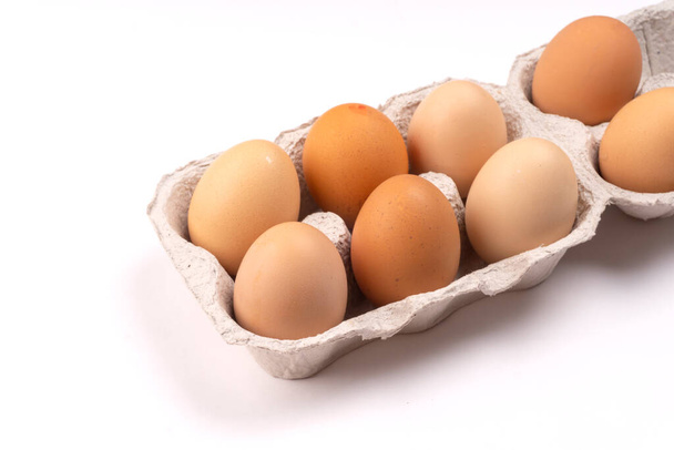 Lepenková krabice s čerstvými kuřecími vejci na bílém pozadí, detailní záběr  - Fotografie, Obrázek