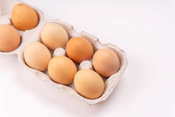 Pahvilaatikko, jossa tuoreita kananmunia valkoisella taustalla, lähikuva  - Valokuva, kuva