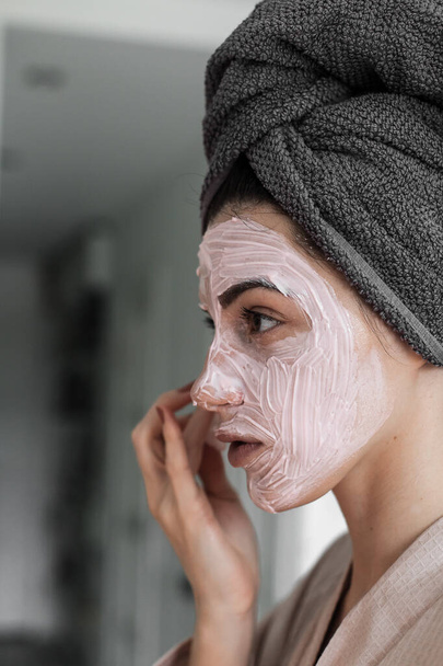 beautiful woman with mask and towel in bathroom - Valokuva, kuva