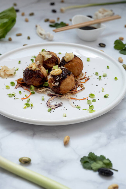 A plate of takoyaki over a marble table - Photo, Image