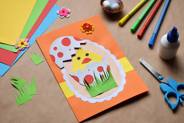 Making of handmade Easter decoration. Child made greeting card in egg shape. Childrens DIY concept, gift with your own hands. Hobby, paper crafts at home or  in kindergarten. - Photo, Image