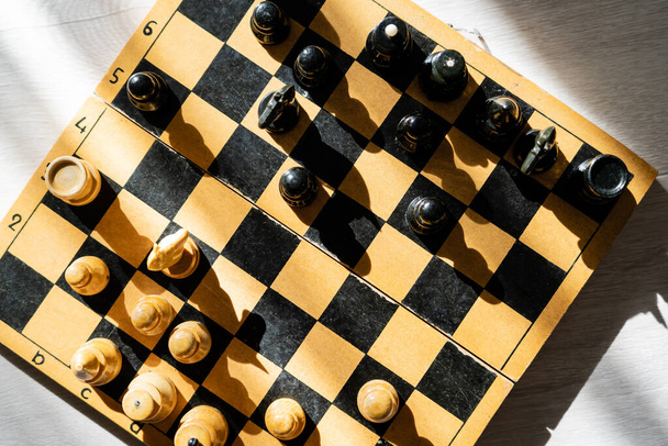 Top view of figures on chessboard on wooden background  - Φωτογραφία, εικόνα