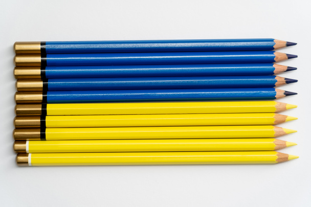 Πάνω όψη του χρώματος μπλε διαφήμιση κίτρινα μολύβια σε λευκό φόντο  - Φωτογραφία, εικόνα