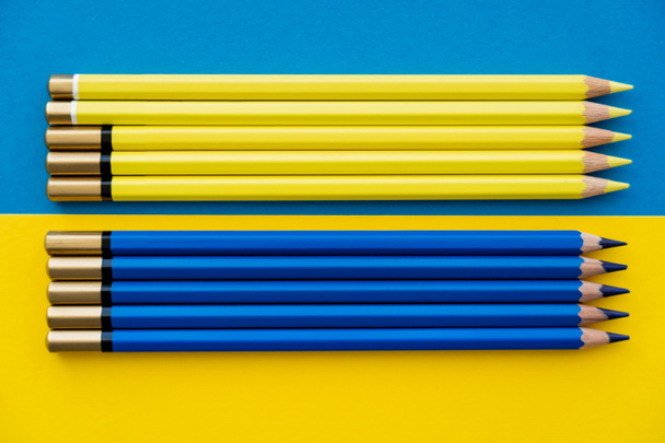 Top view of color pencils on ukrainian flag - Фото, изображение