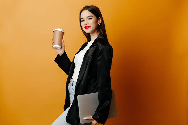 Young woman is dressed casually in a black blazer and a white shirt. The girl is preparing for her working day - Photo, Image