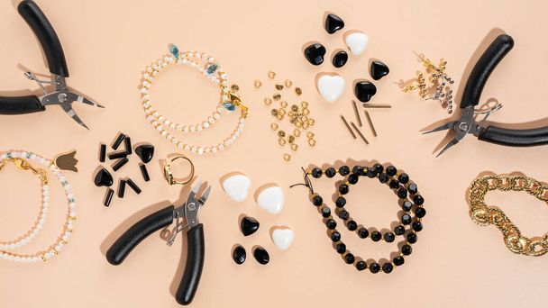 Tools and accessories for DIY jewelry in the workplace. Flat lay on beige background. Creative flat lay, banner, top view. DIY craft hobby, homemade business. Making handmade for friends gifts - Photo, Image