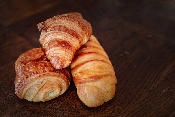 fresh homemade croissants on the wooden background - Foto, afbeelding