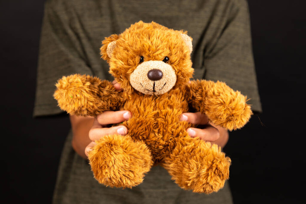 teddy bear with a toy on a black background - Zdjęcie, obraz