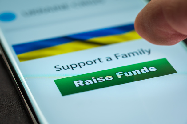 Close-up vinger drukken raise funds knop op smartphone scherm. Donatie geld online concept - Foto, afbeelding