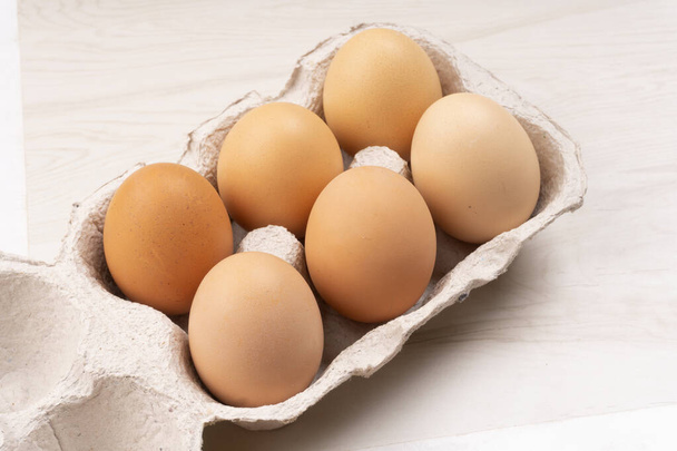 Six chicken eggs in cardboard box, closeup shot  - Photo, Image
