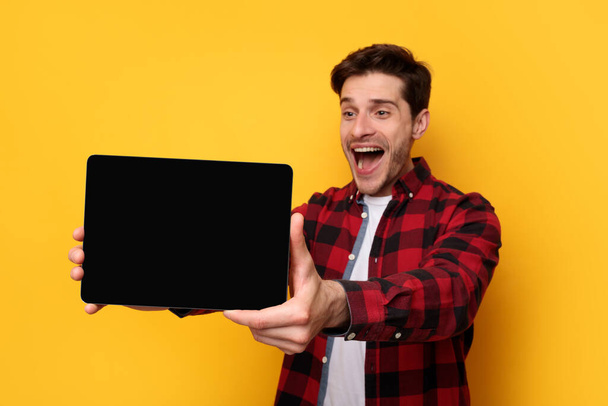 Excited young man showing black empty tablet screen - Photo, Image