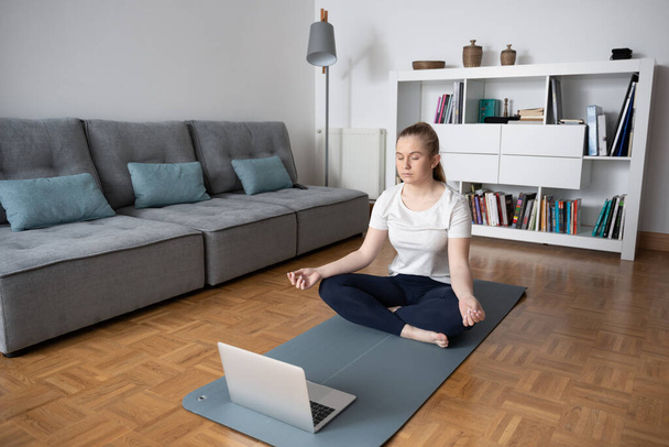 Teenager nimmt virtuellen Yoga-Kurs zu Hause. - Foto, Bild