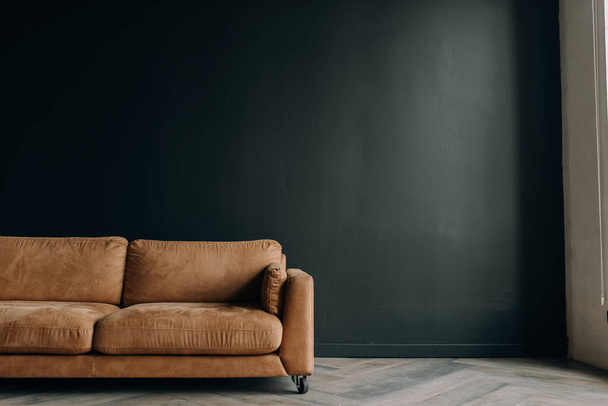 Barna kanapé sötét szürke fali háttérrel. Koncepcionális fotó egy belső térről, egy felirat helyével - Fotó, kép