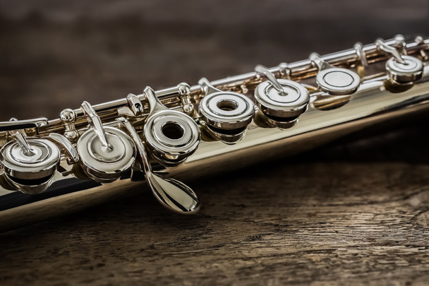 Современная концертная флейта на деревянном столе
 - Фото, изображение